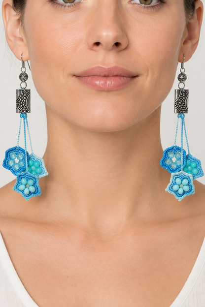 Photo portée des boucles d’oreilles artisanales en coton dégradé bleu avec perles bleu clair et turquoise, crochet en argent sterling