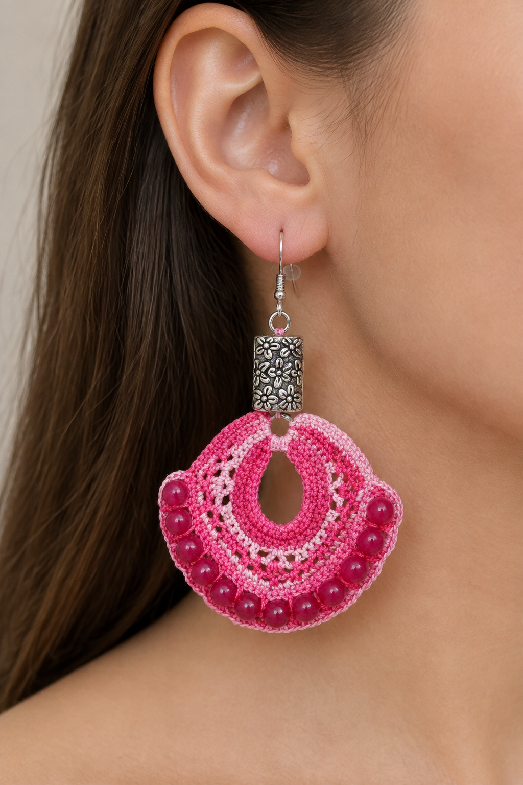 Boucle d’oreille artisanale en coton rose dégradé et perles de rubis ronds portée à l’oreille